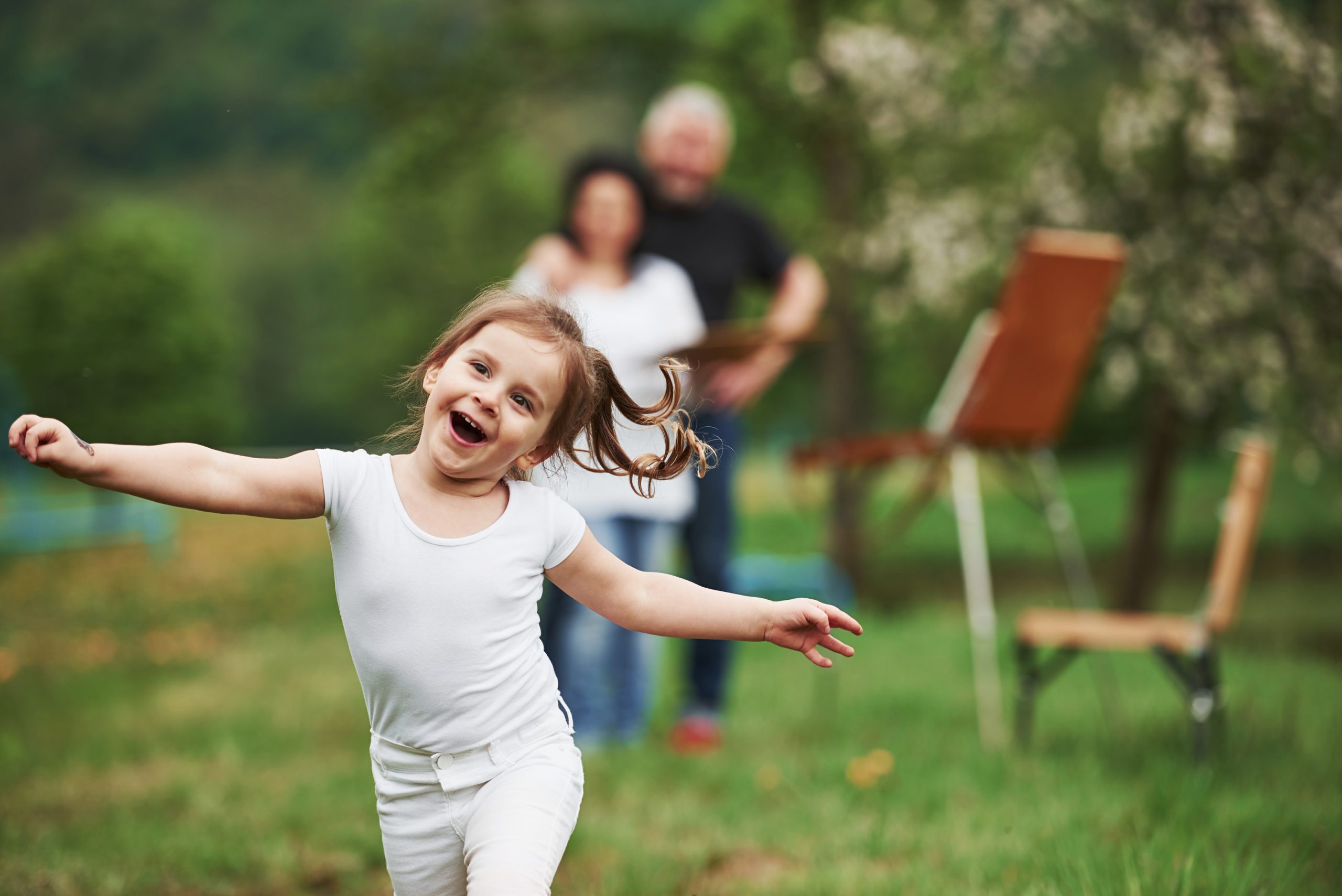 Pure happiness. Grandmother and grandfather have fun outdoors with granddaughter. Painting conception